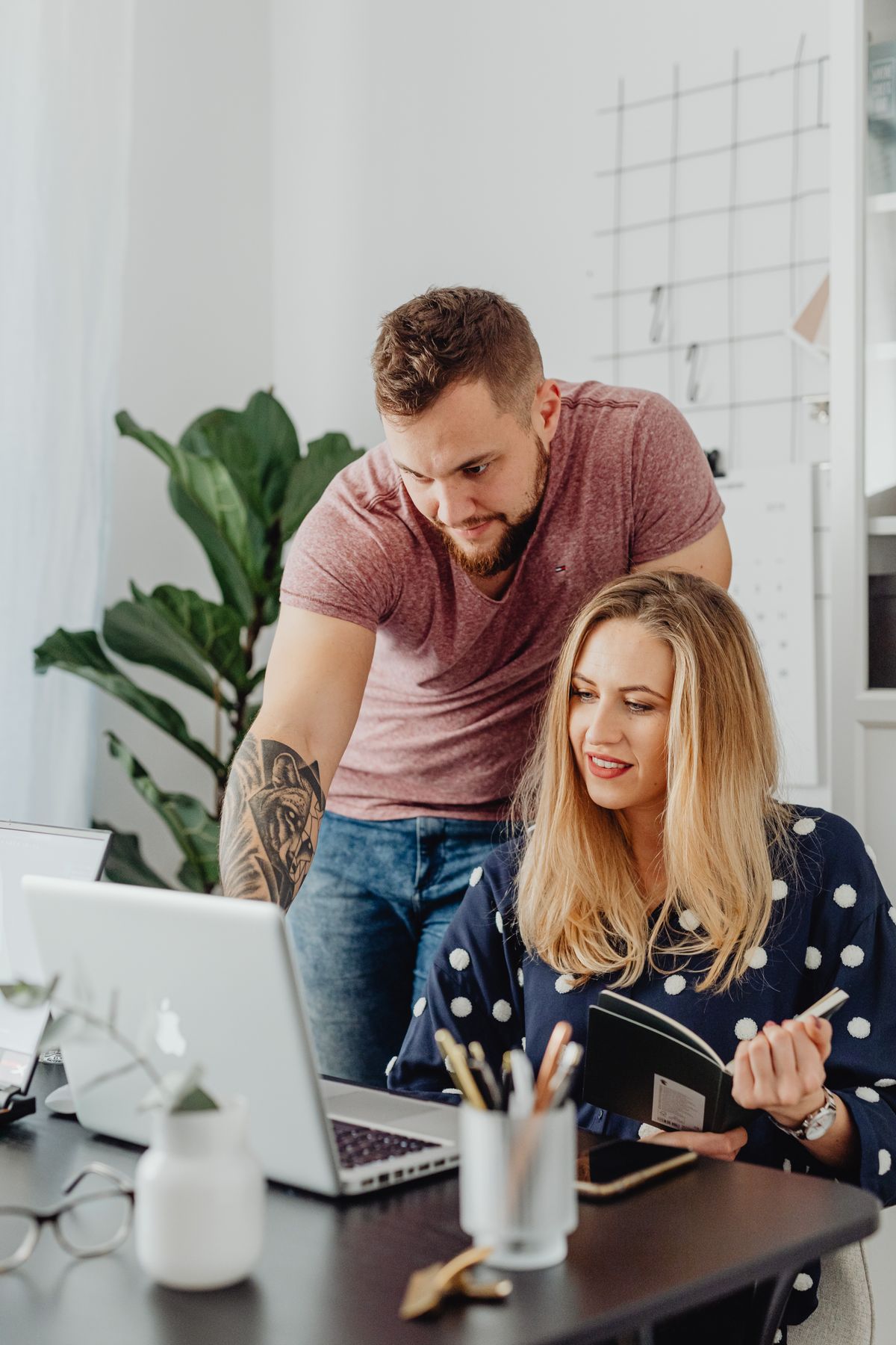 Two colleagues discussing a project in front of a laptop